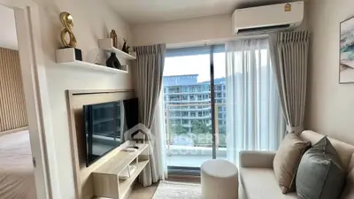 Modern living room with balcony view, stylish decor, and natural light