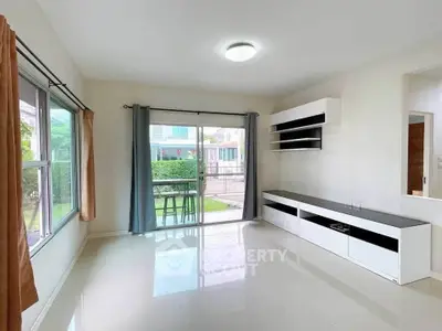 Spacious living room with large windows and modern shelving in a bright home