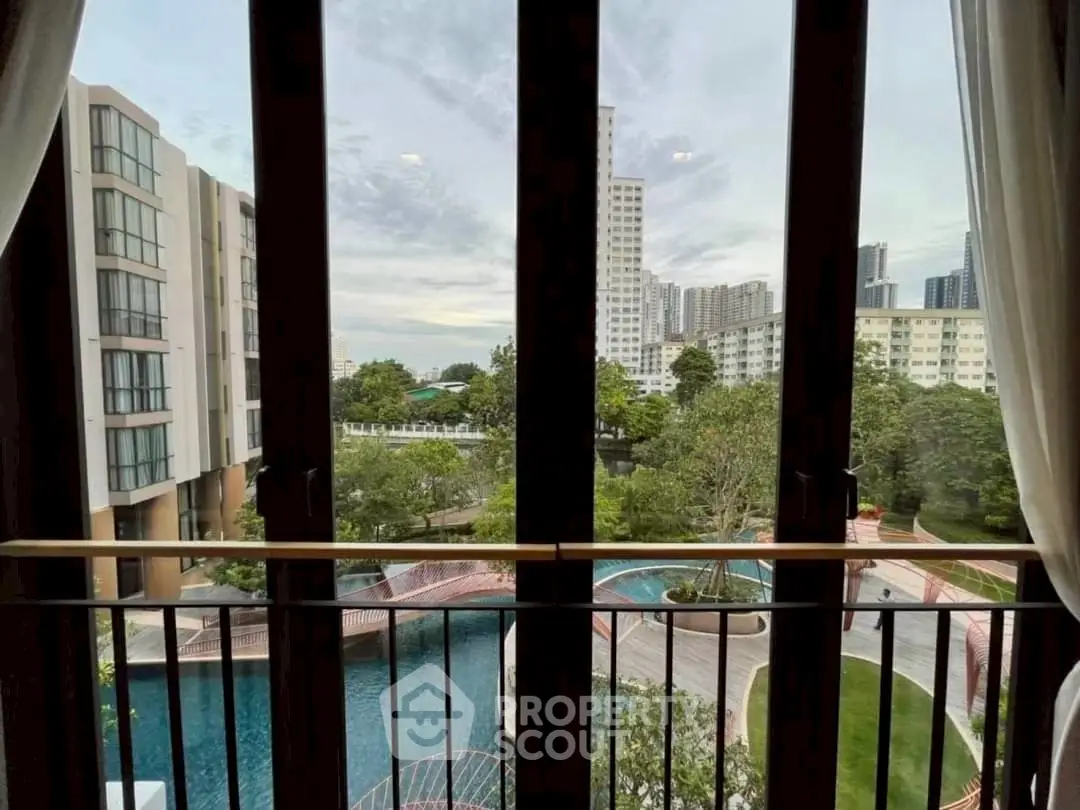 Stunning balcony view overlooking modern pool and lush greenery in urban setting.