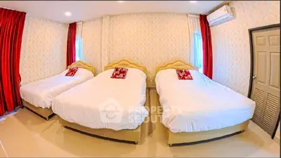 Spacious bedroom with three beds and elegant decor, perfect for family or group accommodation.
