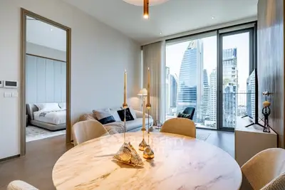 Luxurious modern apartment with stunning city view from dining area and bedroom.