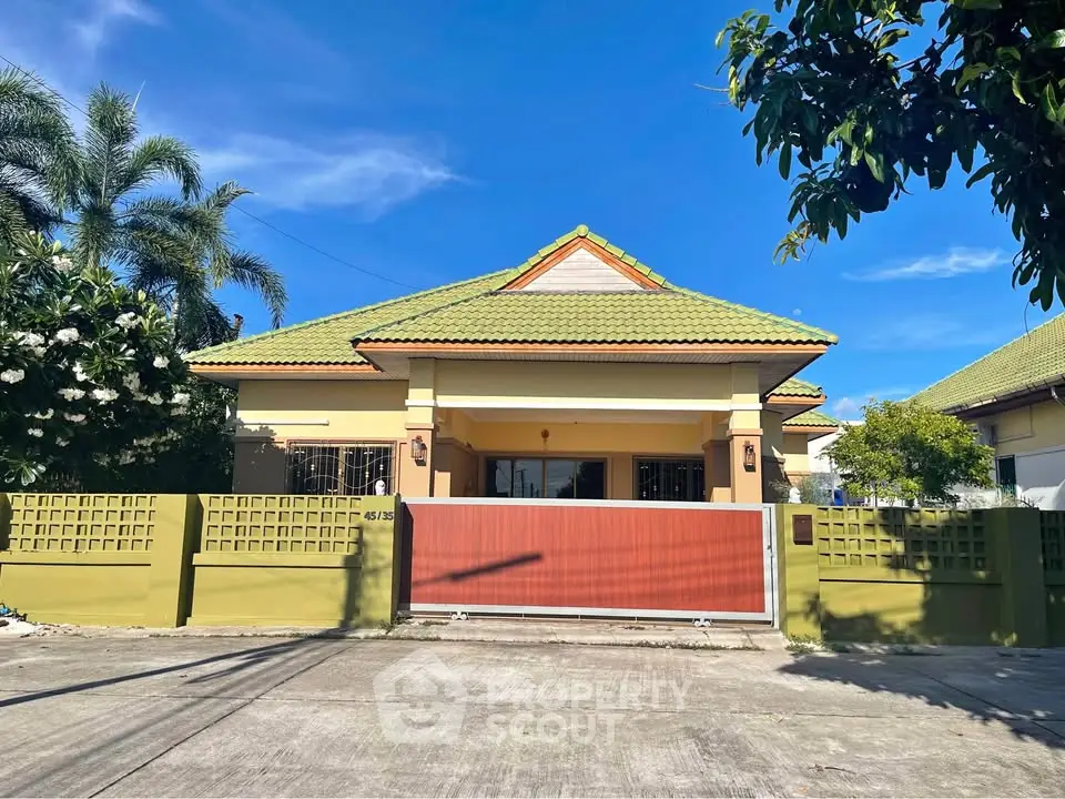 Charming single-story home with green roof and spacious front yard in sunny neighborhood.