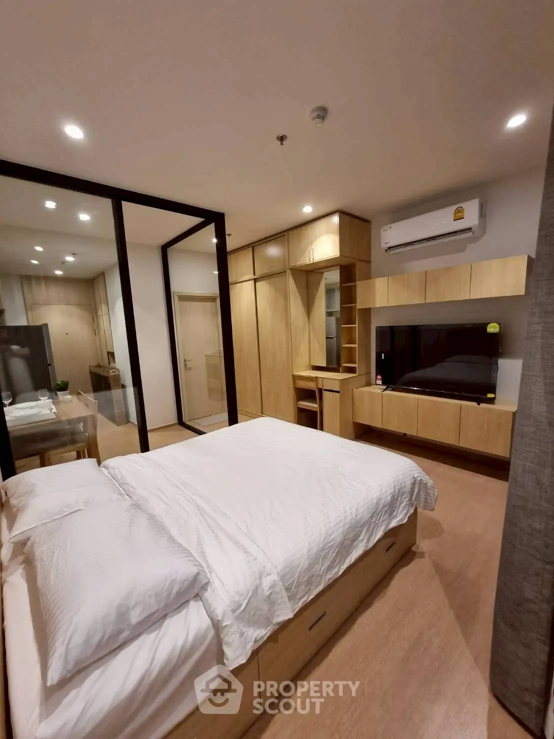 Modern bedroom with wooden furniture and air conditioning in a cozy apartment.
