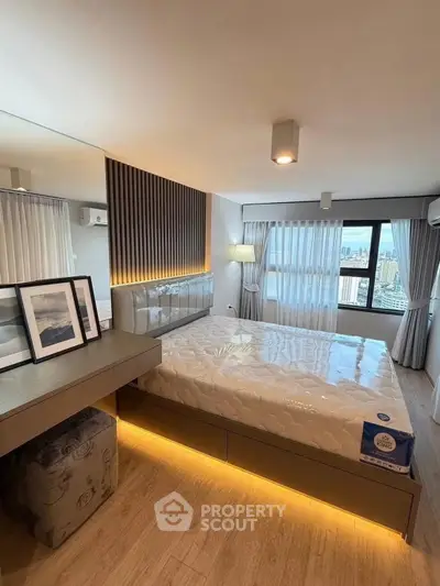 Modern bedroom with city view, featuring stylish decor and ambient lighting.