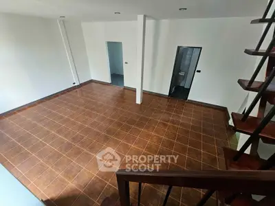 Spacious open-plan living area with tiled flooring and modern staircase, perfect for contemporary living.