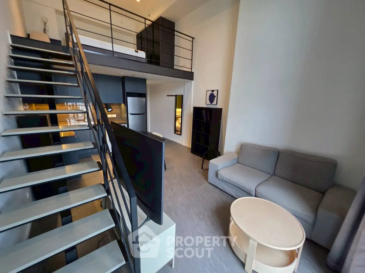 Modern loft-style living room with mezzanine and sleek staircase