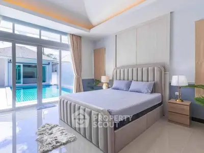 Luxurious bedroom with pool view, modern decor, and elegant furnishings in a serene setting.