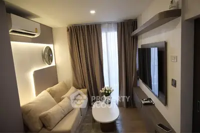 Modern living room with cozy sofa, wall-mounted TV, and elegant lighting
