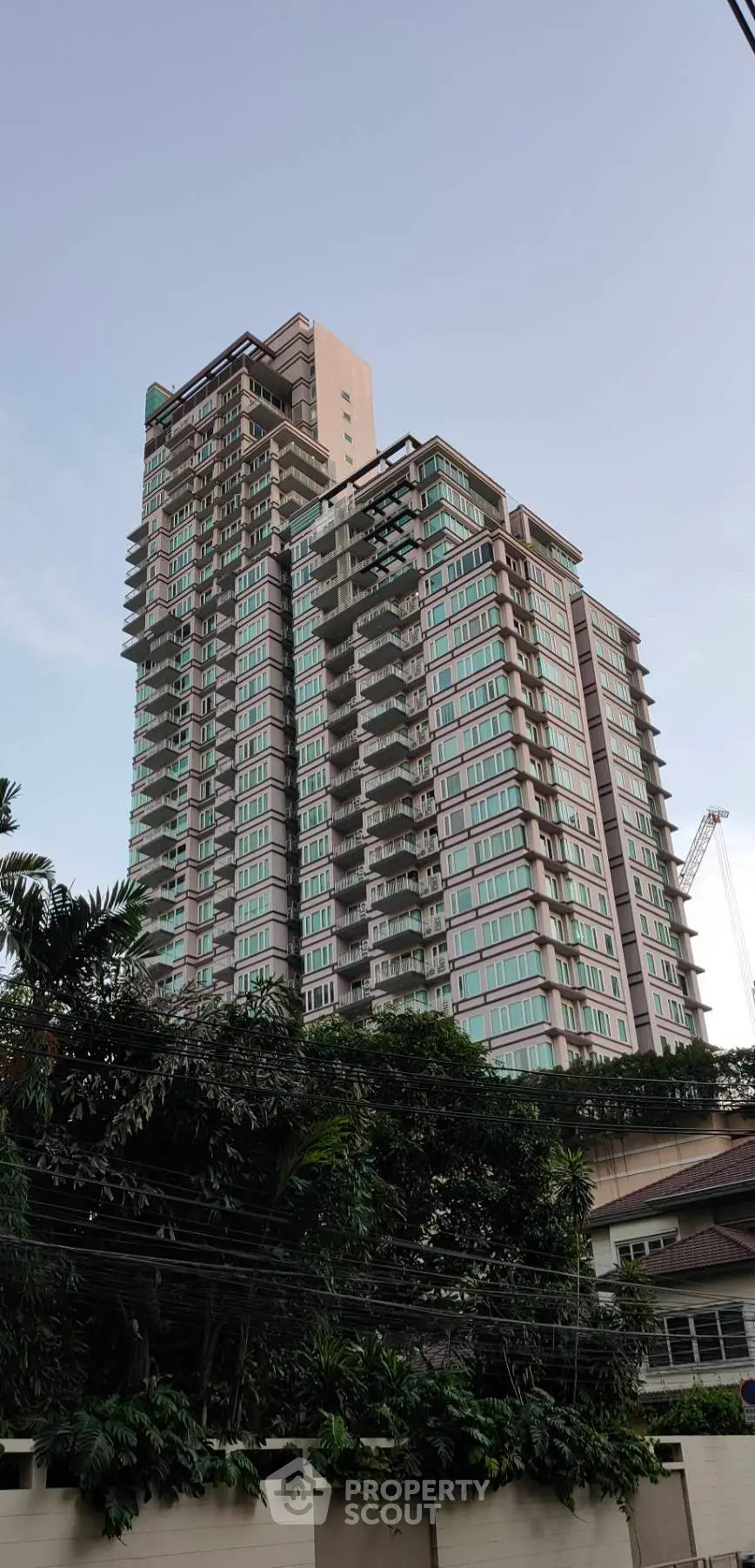 Stunning high-rise building with modern architecture and lush greenery, perfect for urban living.