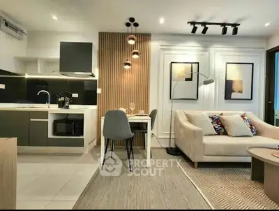 Modern open-plan living room and kitchen with stylish decor and cozy seating area.
