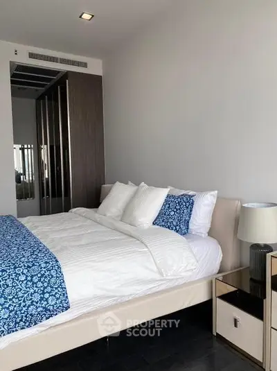 Modern bedroom with stylish decor and ample natural light, featuring a comfortable bed and sleek furnishings.