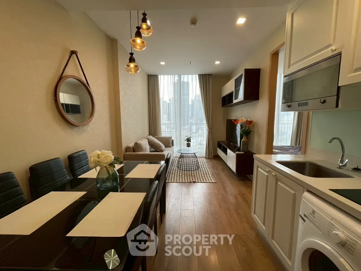 Modern open-layout living room with dining area and city view, featuring stylish decor and natural light.