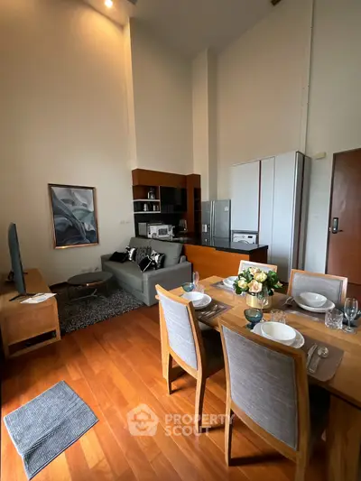 Modern living room with dining area and stylish decor in open layout apartment.