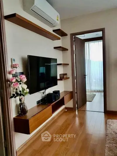 Modern living room with wooden flooring and wall-mounted TV unit