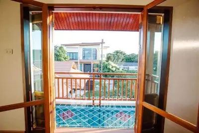 Charming balcony view with wooden accents and scenic neighborhood backdrop.
