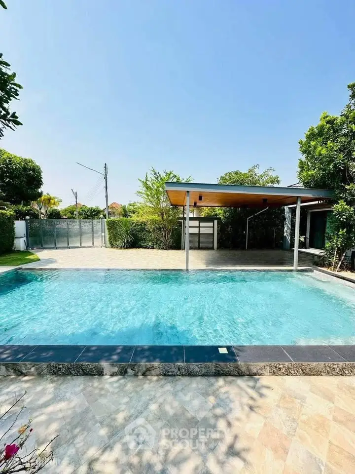 Luxurious outdoor pool area with modern design and lush greenery, perfect for relaxation and entertainment.
