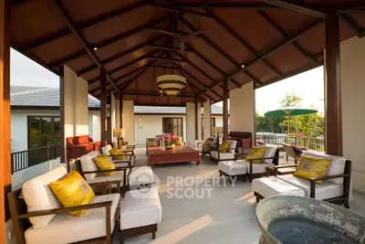 Luxurious open-air living room with elegant wooden ceiling and plush seating in a tropical villa.