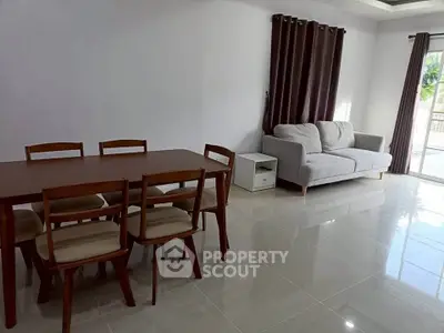 Spacious living room with modern dining set and cozy sofa, perfect for family gatherings.