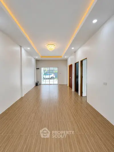 Spacious modern living room with elegant lighting and large windows for natural light.