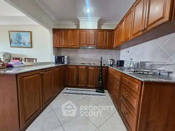 Spacious kitchen with wooden cabinets and modern appliances in a cozy home setting.