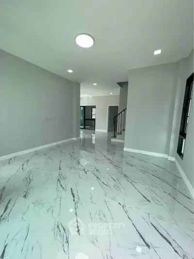 Spacious modern living room with marble flooring and elegant staircase