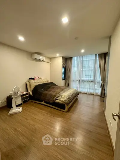 Spacious bedroom with modern design and large window for natural light.