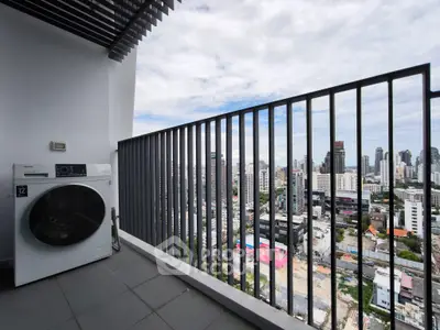 High-rise balcony with city view and washing machine, perfect urban living space.