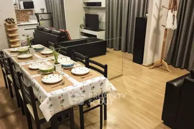 Modern open-plan living and dining area with stylish decor and wooden flooring.