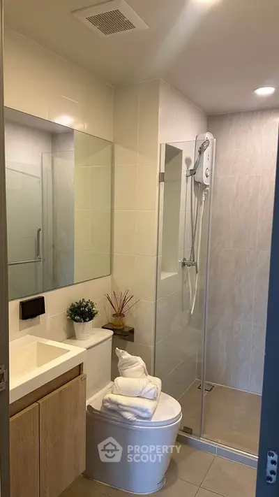 Modern bathroom with glass shower and sleek vanity in a contemporary home.