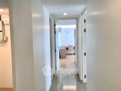 Bright hallway leading to a modern living area with sleek furniture and minimalist design.