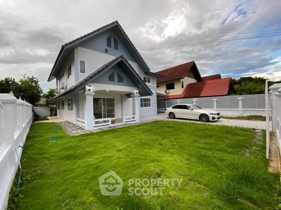 Charming two-story house with lush green lawn and modern car in driveway, perfect for family living.