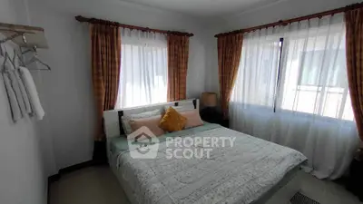 Cozy bedroom with large windows and elegant curtains, perfect for relaxation.