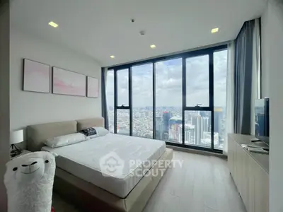 Luxurious bedroom with floor-to-ceiling windows offering stunning city views.