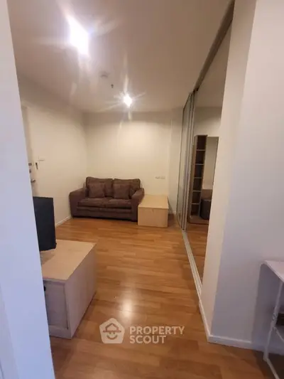 Cozy living room with wooden flooring and comfortable sofa in modern apartment.