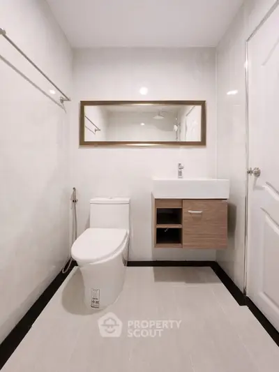 Modern bathroom with sleek fixtures and elegant mirror design.