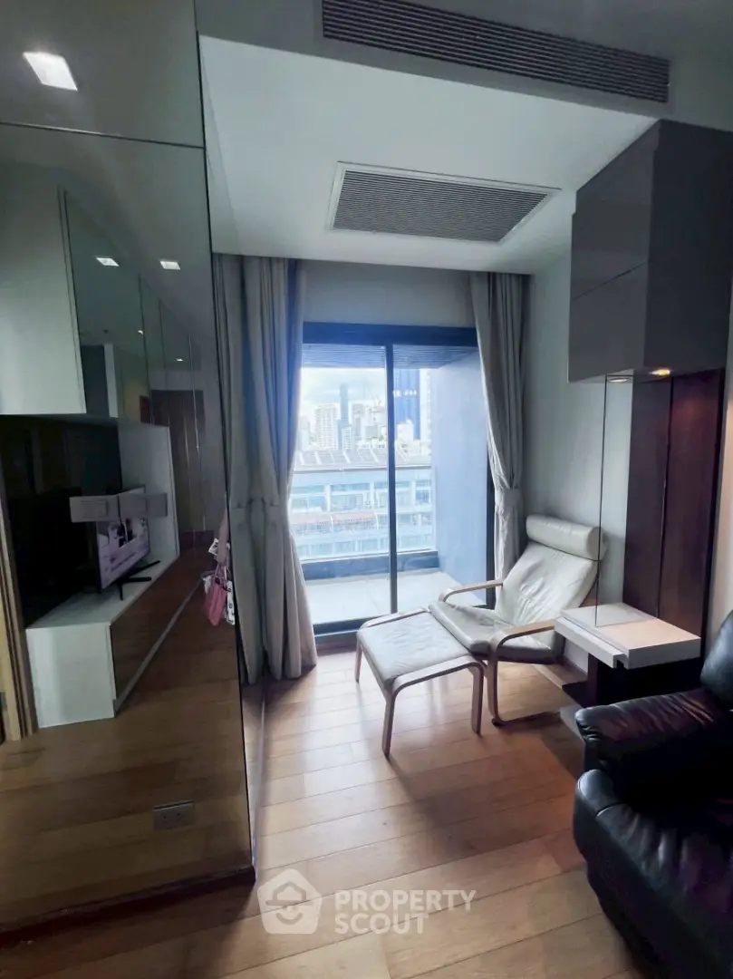 Modern living room with city view, featuring sleek furniture and floor-to-ceiling windows.