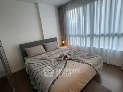 Cozy bedroom with modern decor and large window for natural light