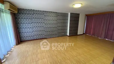 Spacious empty living room with wooden flooring and stylish wallpaper, perfect for customization.