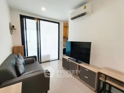Modern living room with sleek furniture and large TV, featuring a cozy ambiance and natural light.