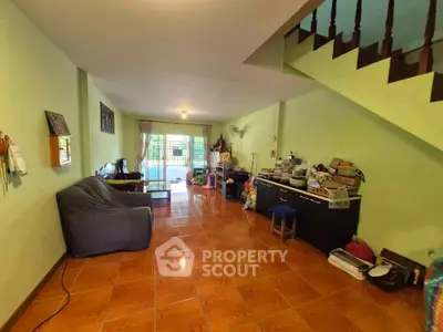 Spacious living room with staircase and tiled floor, perfect for family gatherings.