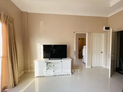 Spacious living room with modern TV stand and natural light