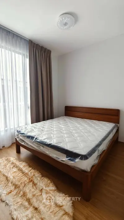 Spacious bedroom with natural light and elegant wooden bed frame