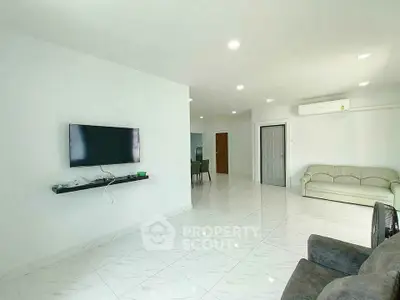 Spacious living room with modern decor and wall-mounted TV