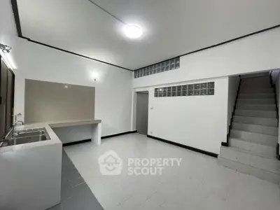 Spacious open-layout kitchen with modern design and staircase