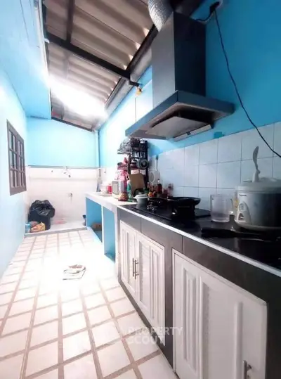 Charming kitchen with open layout and modern appliances in a bright blue setting.
