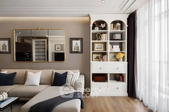 Elegant living room with stylish decor and large window, featuring a cozy sofa and built-in shelving.