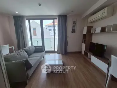 Modern living room with large windows and stylish furniture in a bright apartment.