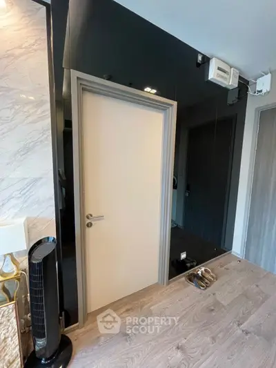 Modern interior with sleek door and stylish flooring, featuring contemporary decor elements.