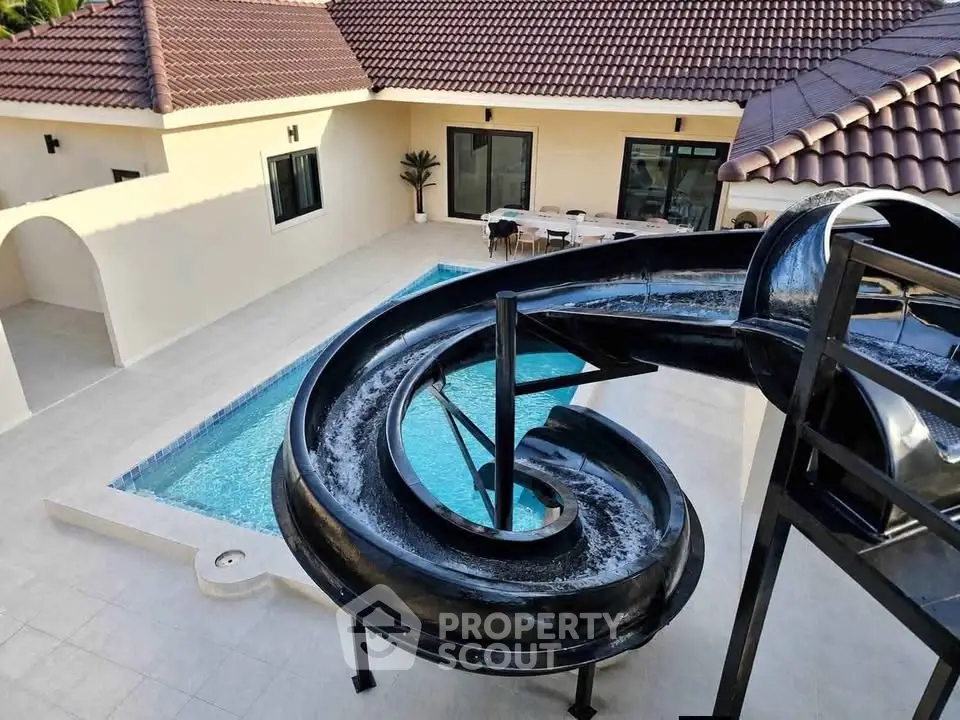 Luxurious villa with private pool and spiral water slide, perfect for family entertainment and relaxation.
