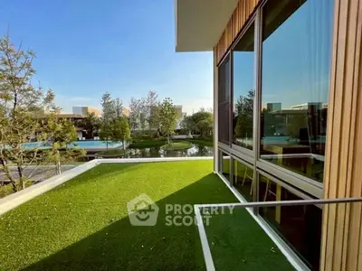 Luxurious modern balcony with lush green view and large glass windows